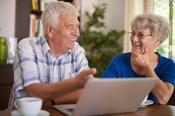 A retired couple at home comparing coverage options on a laptop.